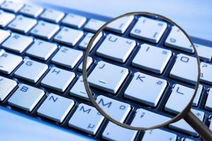 spyware phishing keyboard with looking glas
